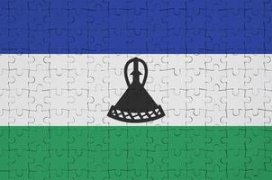 Lesotho flag  is depicted on a folded puzzle photo