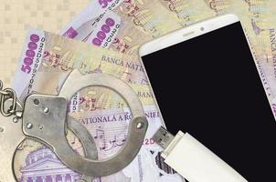 50000 Romanian leu bills and smartphone with police handcuffs. Concept of hackers phishing attacks, illegal scam or malware soft distribution photo