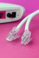 Internet router and Internet cable plugs lie on a bright pink background. Items required for Internet photo