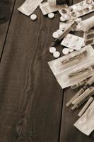 Narcotic stuff with many pills and syringes lies on wooden table and ready to use photo