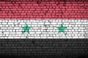 Syria flag is painted onto an old brick wall photo