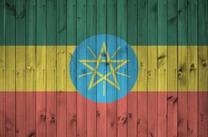 Ethiopia flag depicted in bright paint colors on old wooden wall. Textured banner on rough background photo