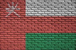 Oman flag is painted onto an old brick wall photo