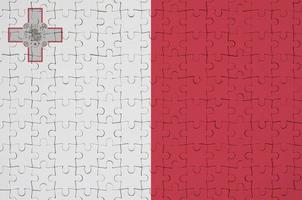 Malta flag  is depicted on a folded puzzle photo