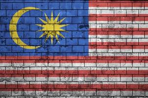 Malaysia flag is painted onto an old brick wall photo