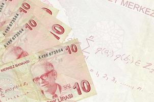 10 Turkish liras bills lies in stack on background of big semi-transparent banknote. Abstract business background photo