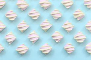 Colorful marshmallow laid out on blue paper background. pastel creative textured pattern. minimal photo