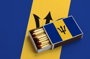 Barbados flag  is shown in an open matchbox, which is filled with matches and lies on a large flag photo