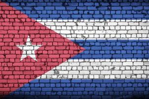 Cuba flag is painted onto an old brick wall photo