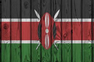 Kenya flag depicted in bright paint colors on old wooden wall. Textured banner on rough background photo