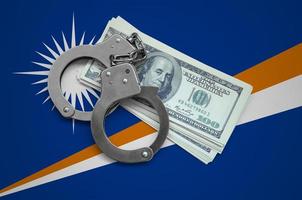 Marshall Islands flag  with handcuffs and a bundle of dollars. Currency corruption in the country. Financial crimes photo