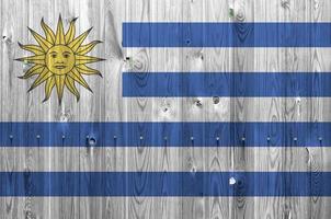 Uruguay flag depicted in bright paint colors on old wooden wall. Textured banner on rough background photo