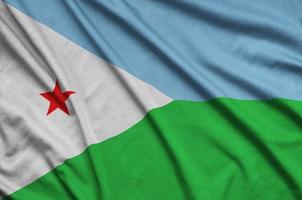 Djibouti flag  is depicted on a sports cloth fabric with many folds. Sport team banner photo