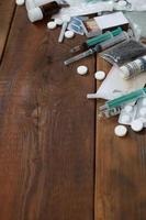 A lot of narcotic substances and devices for the preparation of drugs lie on an old wooden table photo