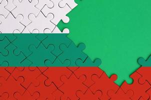 Bulgaria flag  is depicted on a completed jigsaw puzzle with free green copy space on the right side photo