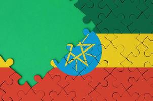Ethiopia flag  is depicted on a completed jigsaw puzzle with free green copy space on the left side photo