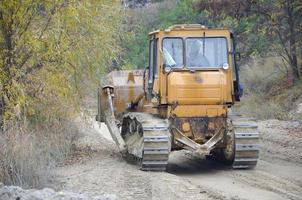 agregado de cantera con maquinaria pesada. Excavadora de oruga con retroexcavadora que conduce a la cantera del sitio de construcción foto