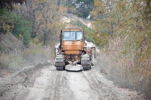 agregado de cantera con maquinaria pesada. Excavadora de oruga con retroexcavadora que conduce a la cantera del sitio de construcción foto