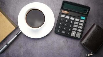 een koffie beker, rekenmachine en munt portemonnee Aan de tafel video