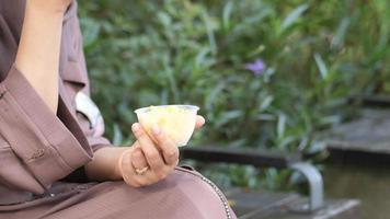 Woman eats corn in a plastic cup video