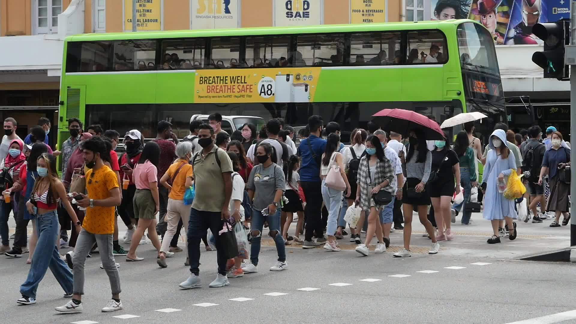 Slow motion of many pedestrians walking at a cross walk wearing masks