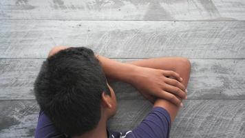 Young boy rests head on crossed arms