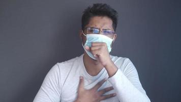 el hombre tose mientras usa una máscara video