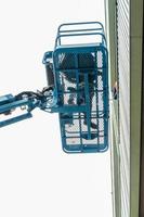 High-rise building maintenance engineers using cranes photo