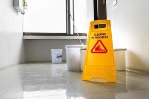 Close up yellow warning sign with message Cleaning in progress photo