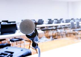 Micrófono y portátil sobre el discurso borroso abstracto en la sala de seminarios
