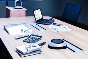 Laptop and meeting equipment on table in meeting room photo