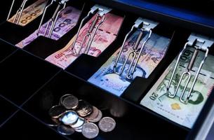 Los billetes y monedas de banco tailandés están en el cajero automático foto