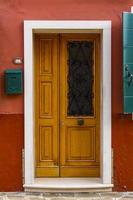 Old traditional door on colorful building at Burano island, Italy photo