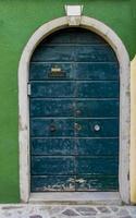 antigua puerta tradicional en un edificio colorido en la isla de burano, italia foto