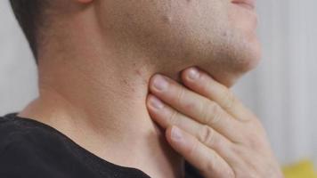 Throat ache. Sick man. The man with the goiter. Man holding his throat with his hands. video