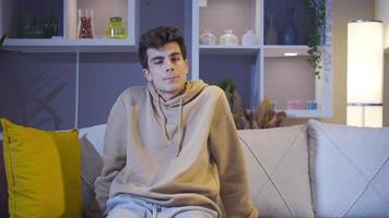 depressief en eenzaam Mens zittend Aan sofa Bij huis. de Mens wie looks in de omgeving van met wanhoop en droefheid is alleen. video