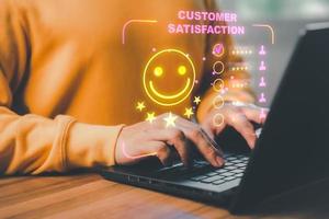 Man hand using computer laptop with popup five star icon for feedback review satisfaction service, testimonial. Customer service experience and business satisfaction survey. photo