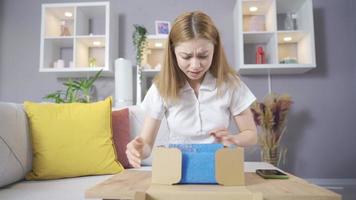 The woman is opening the cargo box. Wrong order, shipping. The woman who opens the cargo box is unhappy and the wrong item has arrived. video