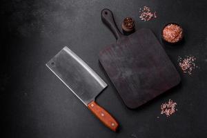 Wooden cutting board with kitchen appliances on a black concrete background photo