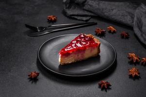 Homemade tasty cheesecake with jelly and raspberry berries on a black plate photo