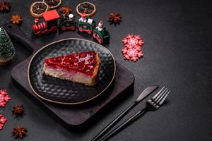 Homemade tasty cheesecake with jelly and raspberry berries on a black plate photo