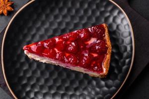 Homemade tasty cheesecake with jelly and raspberry berries on a black plate photo