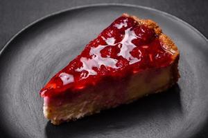 Homemade tasty cheesecake with jelly and raspberry berries on a black plate photo