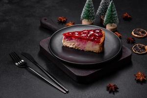 Homemade tasty cheesecake with jelly and raspberry berries on a black plate photo