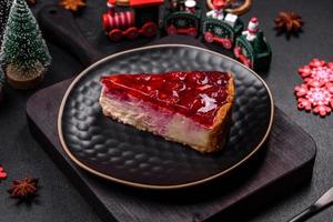 Homemade tasty cheesecake with jelly and raspberry berries on a black plate photo