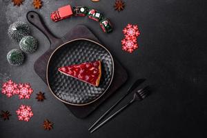 Homemade tasty cheesecake with jelly and raspberry berries on a black plate photo