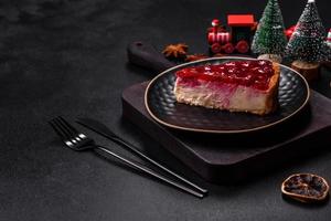 Homemade tasty cheesecake with jelly and raspberry berries on a black plate photo