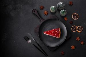 Homemade tasty cheesecake with jelly and raspberry berries on a black plate photo