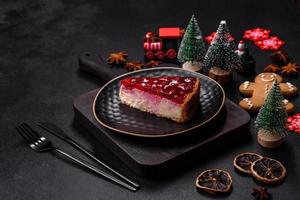 Homemade tasty cheesecake with jelly and raspberry berries on a black plate photo