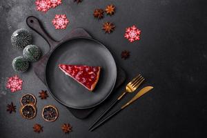 Homemade tasty cheesecake with jelly and raspberry berries on a black plate photo